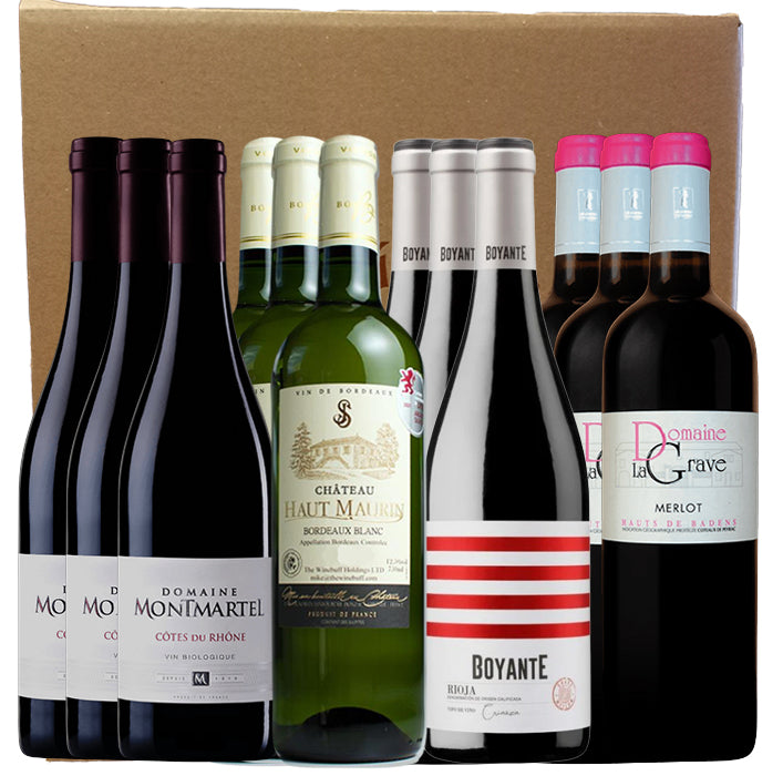 Collection of wine bottles with visible brand labels on a cardboard box background.